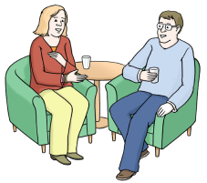 Zwei Personen sitzen in Sesseln und reden.